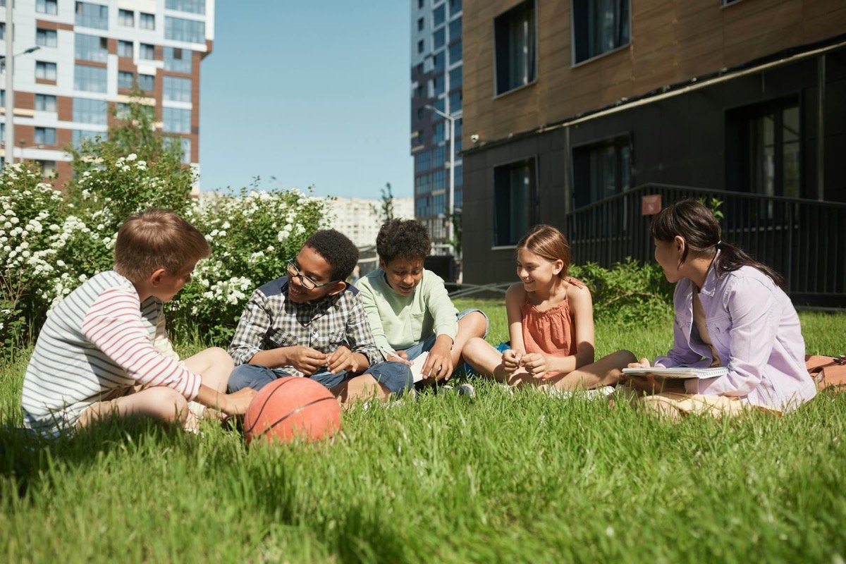Grupo de niños compartiendo y aprendiendo juntos al aire libre