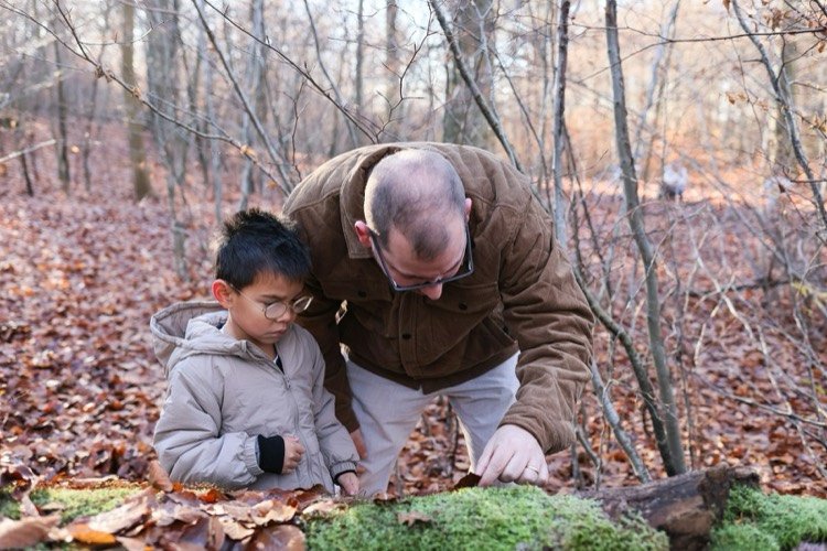 Adulto y niño observando la naturaleza en el bosque